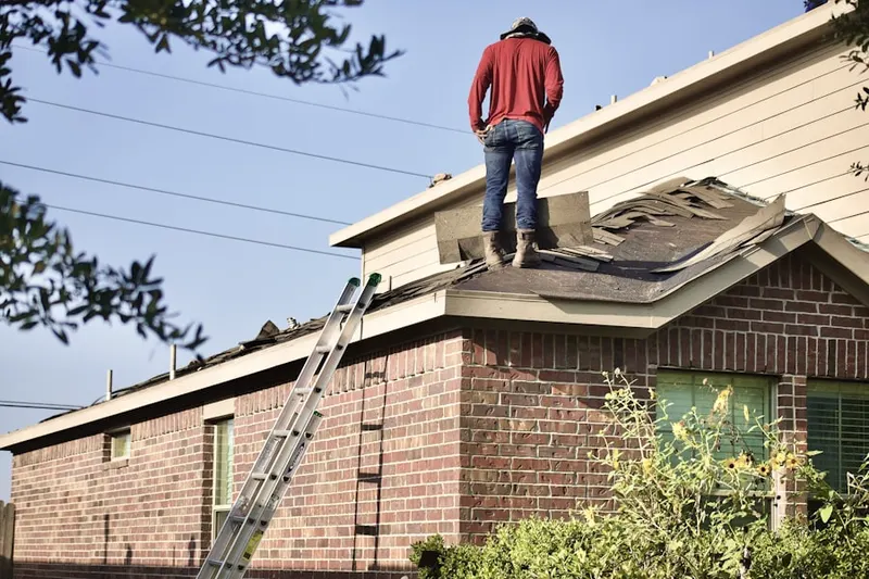 Professional roofer working on a residential roof in Sheridan Forest